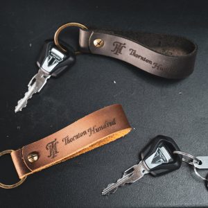 a picture of a black leather hagkeyring and a brown leather tag keyring